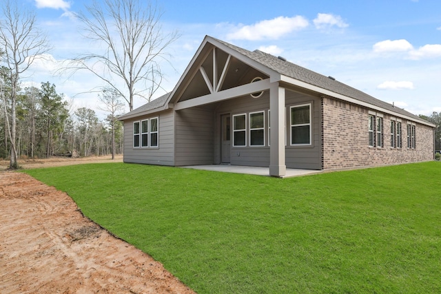 back of house featuring a patio area and a lawn