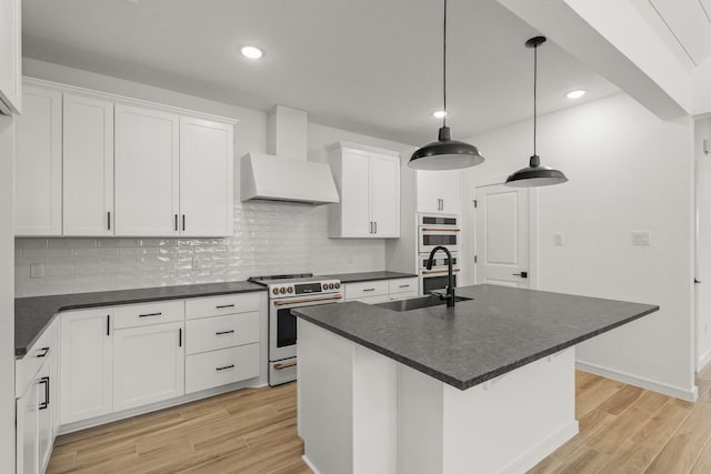 kitchen with white cabinetry, sink, hanging light fixtures, wall chimney range hood, and electric stove