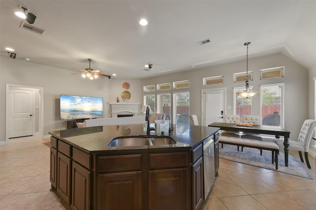 kitchen featuring decorative light fixtures, dishwasher, sink, a kitchen island with sink, and light tile patterned floors