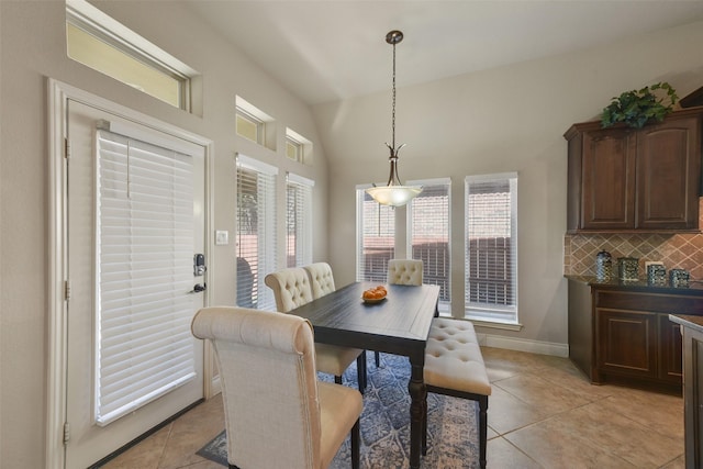 dining area with lofted ceiling and light tile patterned floors