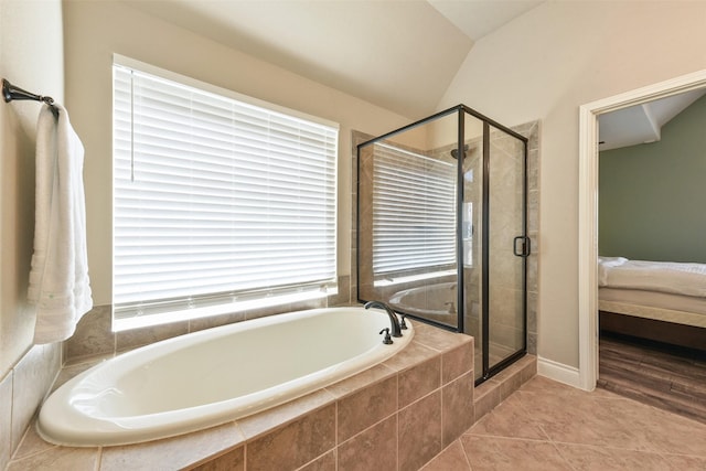 bathroom with tile patterned flooring, vaulted ceiling, and plus walk in shower