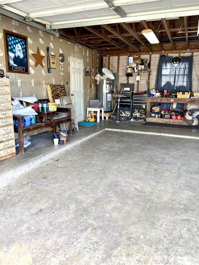 garage featuring electric water heater and a workshop area