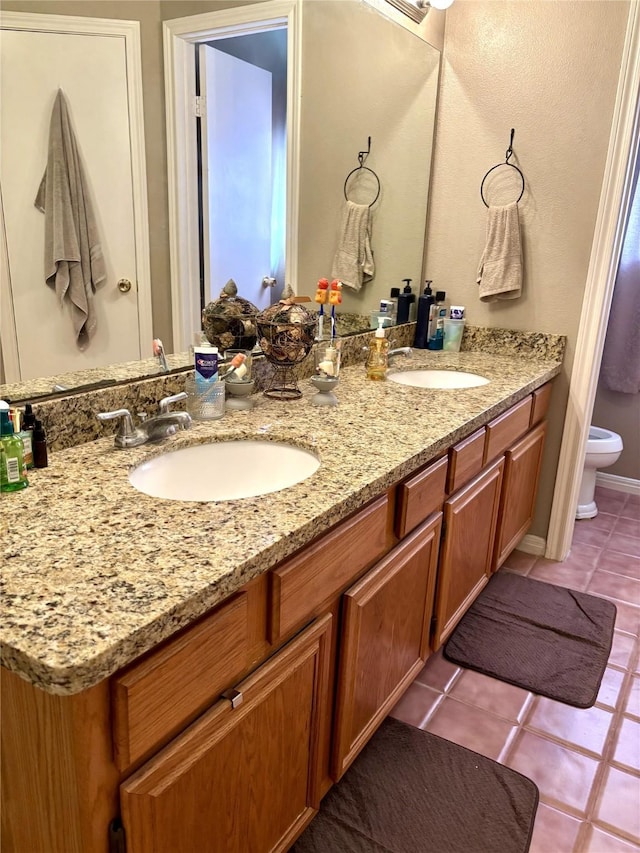 bathroom with vanity, tile patterned flooring, and toilet