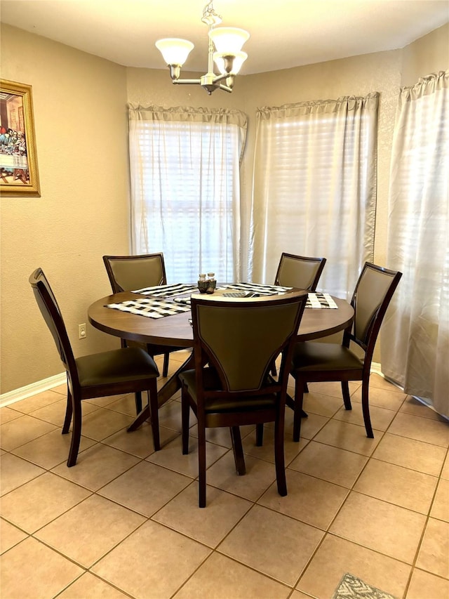 dining area featuring light tile patterned floors and a chandelier