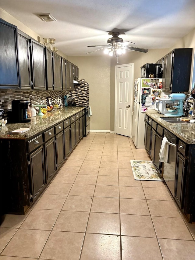 kitchen featuring tasteful backsplash, light tile patterned floors, dark stone counters, and appliances with stainless steel finishes