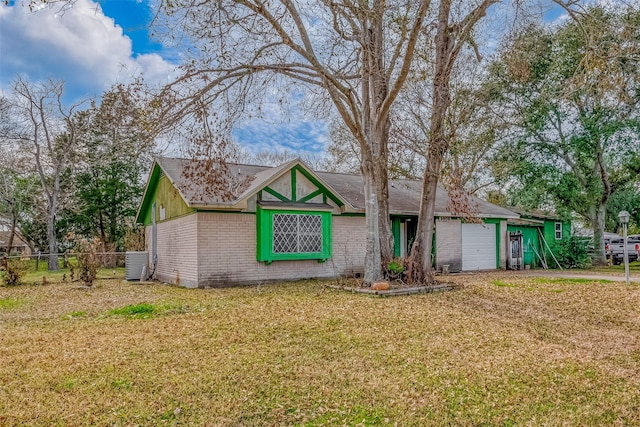 view of front facade with cooling unit, a garage, and a front lawn