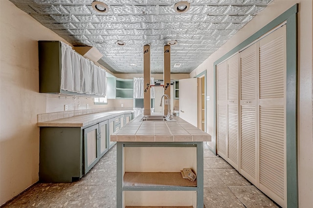 kitchen featuring sink, tile counters, and gray cabinetry