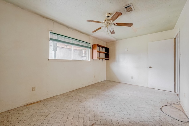 empty room featuring a textured ceiling and ceiling fan