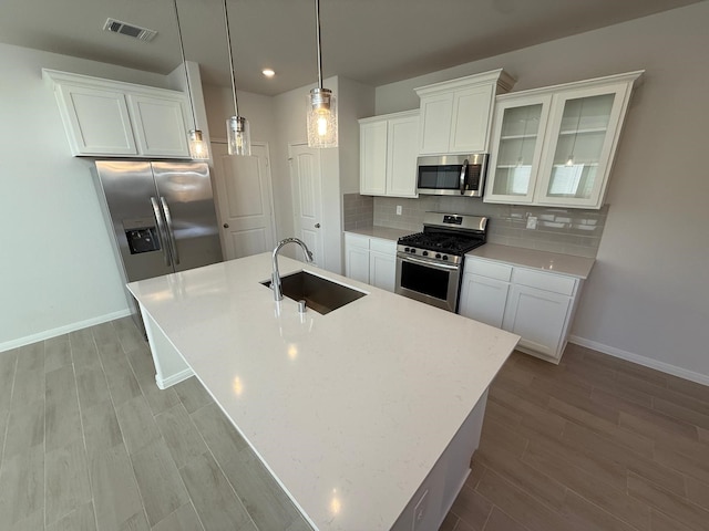 kitchen with white cabinetry, sink, decorative light fixtures, and stainless steel appliances