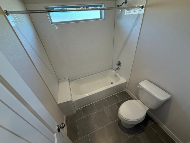 bathroom with tiled shower / bath, tile patterned floors, and toilet