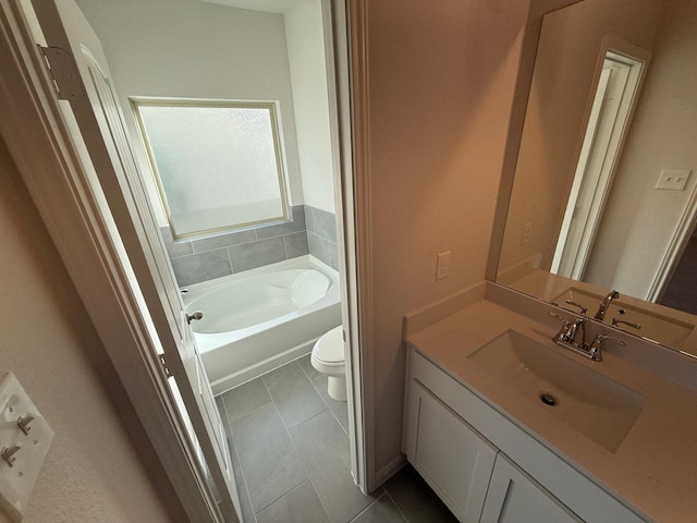 bathroom with tile patterned floors, toilet, a bathing tub, and vanity