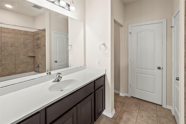 bathroom with tiled shower / bath, tile patterned floors, and vanity