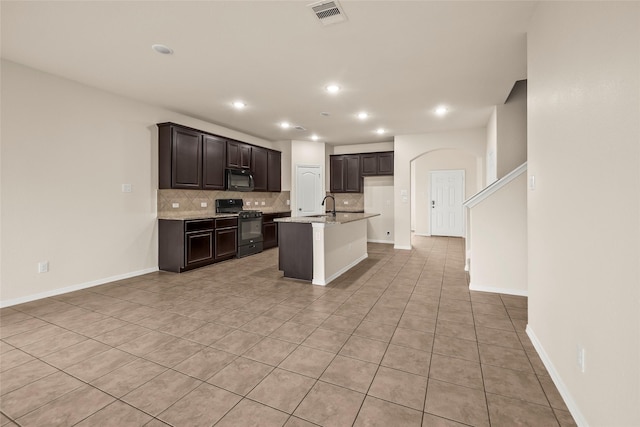 kitchen with backsplash, sink, a kitchen island with sink, and black appliances