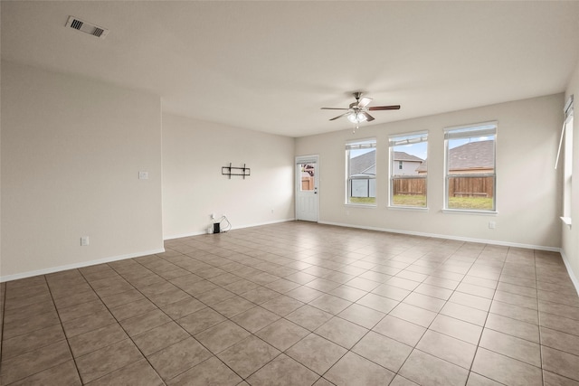 tiled spare room with ceiling fan