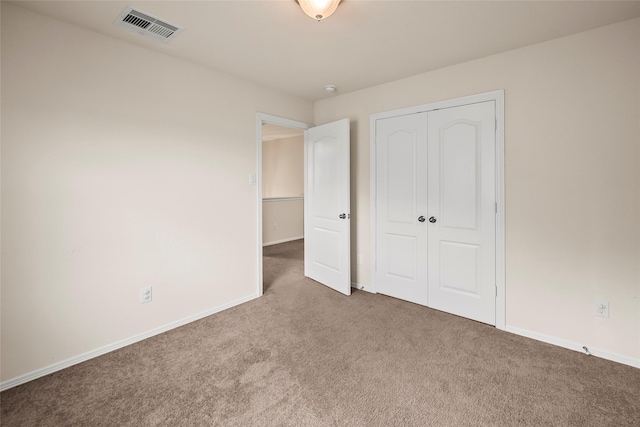 unfurnished bedroom featuring dark carpet and a closet