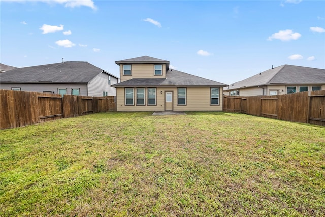 rear view of property featuring a lawn