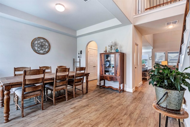 dining room with a high ceiling and light wood-type flooring