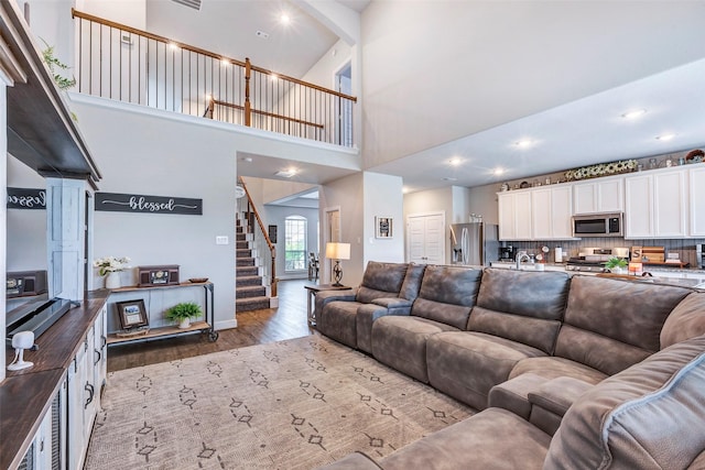 living room featuring light hardwood / wood-style flooring and a high ceiling