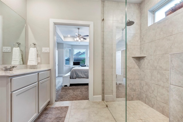 bathroom with ceiling fan, vanity, a tile shower, and a wealth of natural light