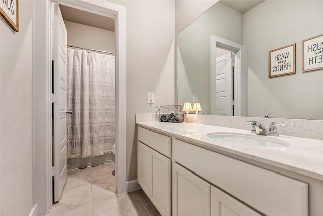 bathroom featuring walk in shower, vanity, toilet, and tile patterned flooring