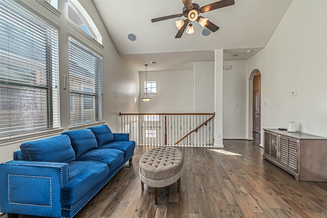 living room with dark hardwood / wood-style flooring, high vaulted ceiling, and ceiling fan