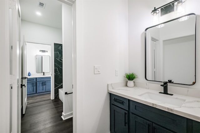 bathroom featuring vanity, hardwood / wood-style flooring, and washtub / shower combination