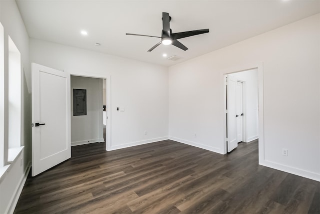 spare room with dark hardwood / wood-style flooring, electric panel, and ceiling fan