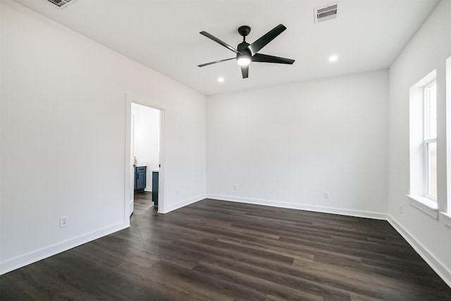 spare room featuring dark wood-type flooring and ceiling fan