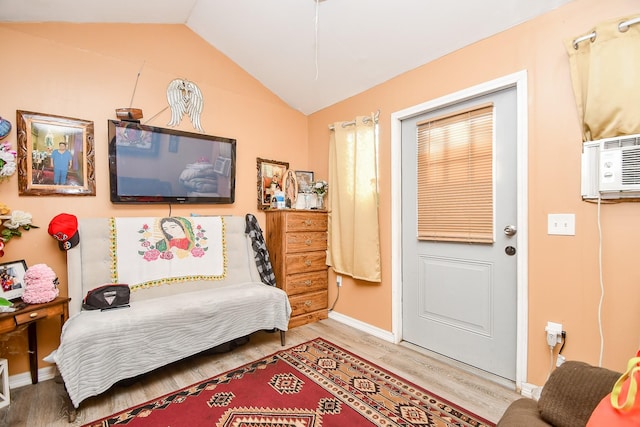 interior space with hardwood / wood-style flooring, vaulted ceiling, and a wall mounted AC