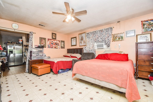 bedroom featuring cooling unit, a textured ceiling, stainless steel fridge, and ceiling fan