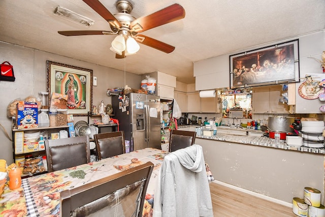 dining space featuring ceiling fan, light hardwood / wood-style flooring, and a textured ceiling