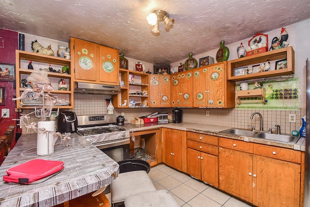 kitchen featuring sink, stainless steel stove, decorative backsplash, and light tile patterned flooring