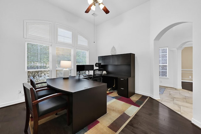 home office featuring decorative columns, high vaulted ceiling, ceiling fan, and light hardwood / wood-style floors