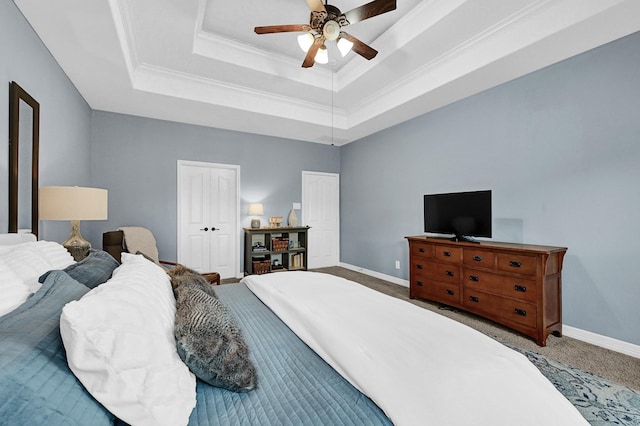 bedroom featuring crown molding, ceiling fan, a tray ceiling, carpet floors, and a closet