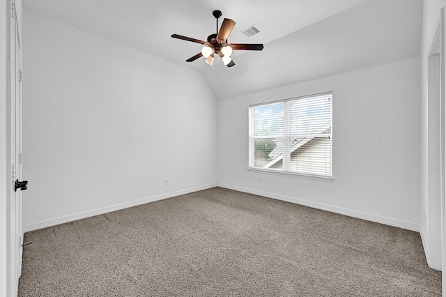 carpeted spare room with ceiling fan and vaulted ceiling