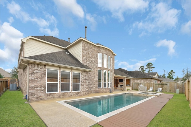 rear view of property featuring a fenced in pool, a yard, a patio, and central AC unit