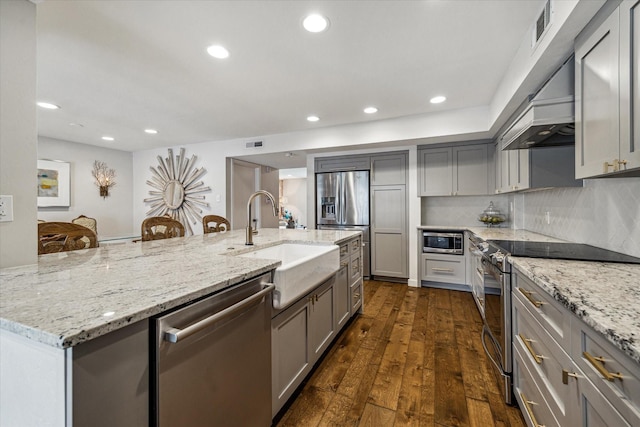 7533 Del Monte Dr, Houston, TX 77063 - kitchen featuring dark wood finished floors, an island with sink, a sink, gray cabinetry, and appliances with stainless steel finishes