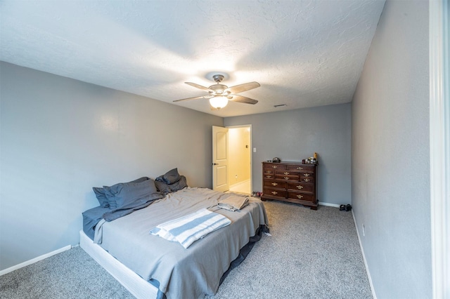 carpeted bedroom featuring ceiling fan and a textured ceiling