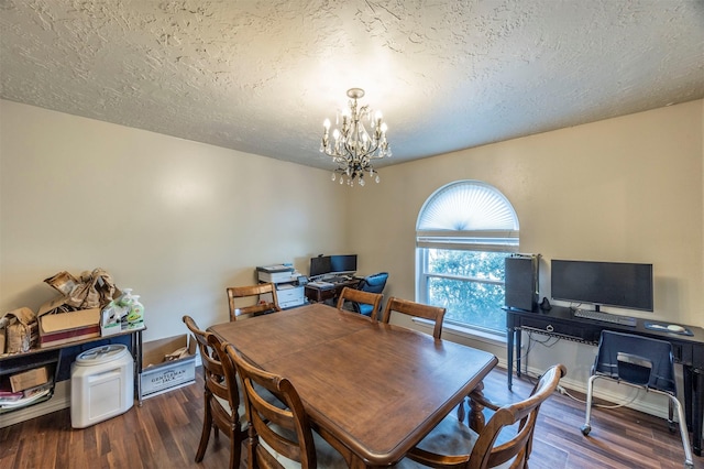 dining space featuring dark wood-type flooring, a textured ceiling, and a notable chandelier