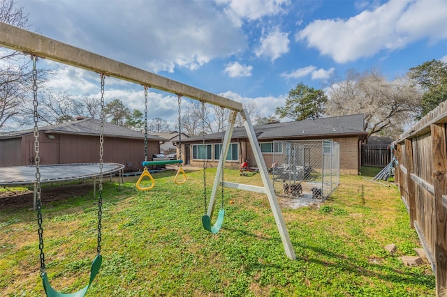 view of yard featuring a playground and a trampoline