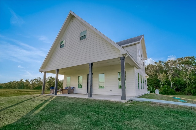 rear view of property featuring a lawn and a patio