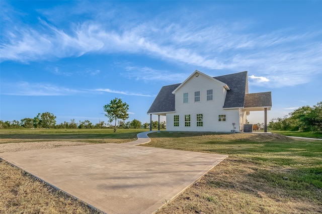 back of property featuring a yard and central AC