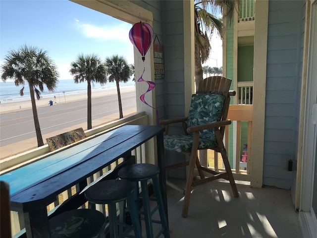 balcony featuring a water view and a beach view