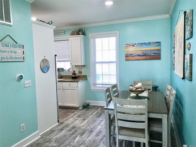 dining room with ornamental molding and hardwood / wood-style floors