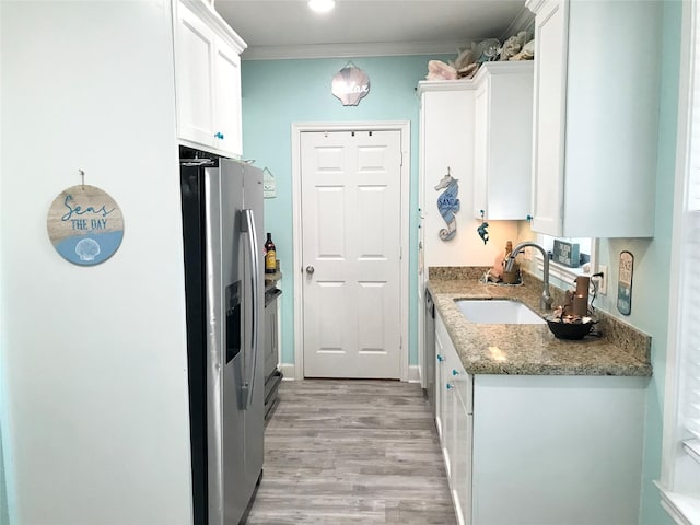 kitchen featuring stone counters, white cabinetry, sink, ornamental molding, and stainless steel fridge with ice dispenser