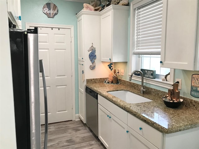 kitchen featuring sink, stainless steel appliances, white cabinets, and light stone countertops