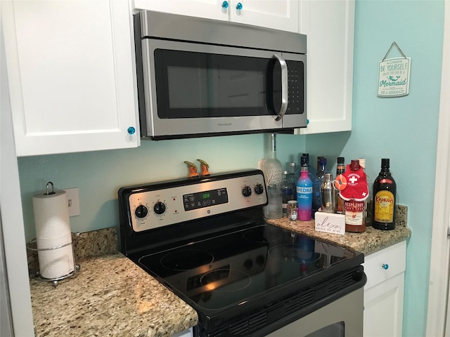 kitchen with white cabinetry, light stone countertops, and appliances with stainless steel finishes