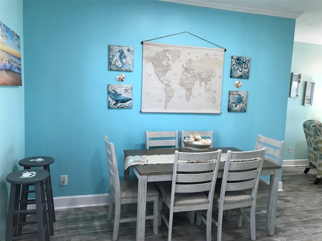 dining space with ornamental molding and dark hardwood / wood-style floors