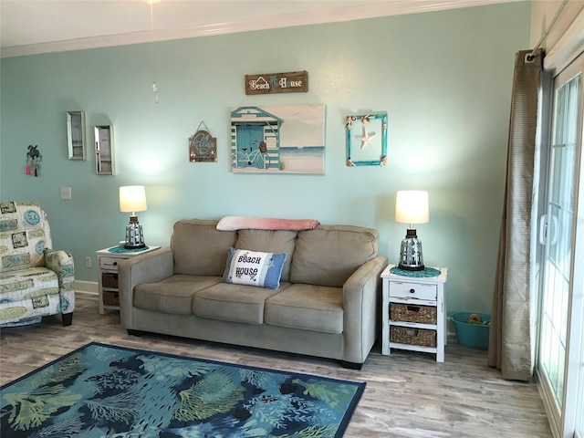 living room featuring crown molding, a healthy amount of sunlight, and hardwood / wood-style flooring