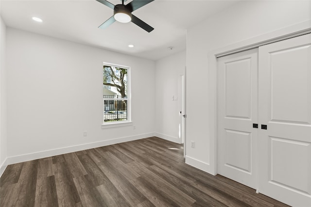 unfurnished bedroom featuring dark wood-type flooring, a closet, and ceiling fan